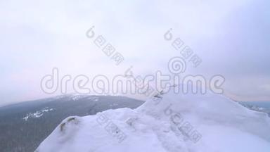 一个年轻<strong>人</strong>，一个游客，<strong>站在</strong>一座白雪覆盖的山的边缘，欣赏<strong>山顶</strong>。